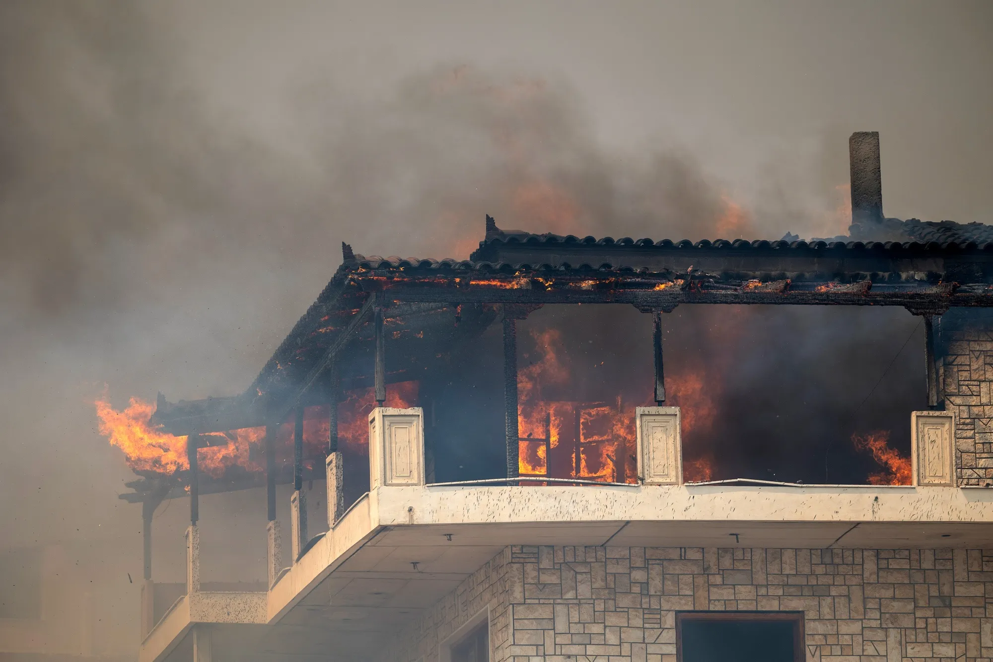 A home on fire during a wildfire in Acharnais suburb, northeast of Athens, Greece, on Aug. 23.