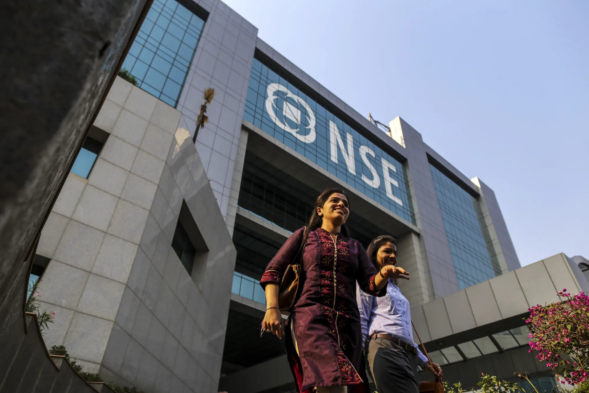 Employees walk past the National Stock Exchange of India in Mumbai.