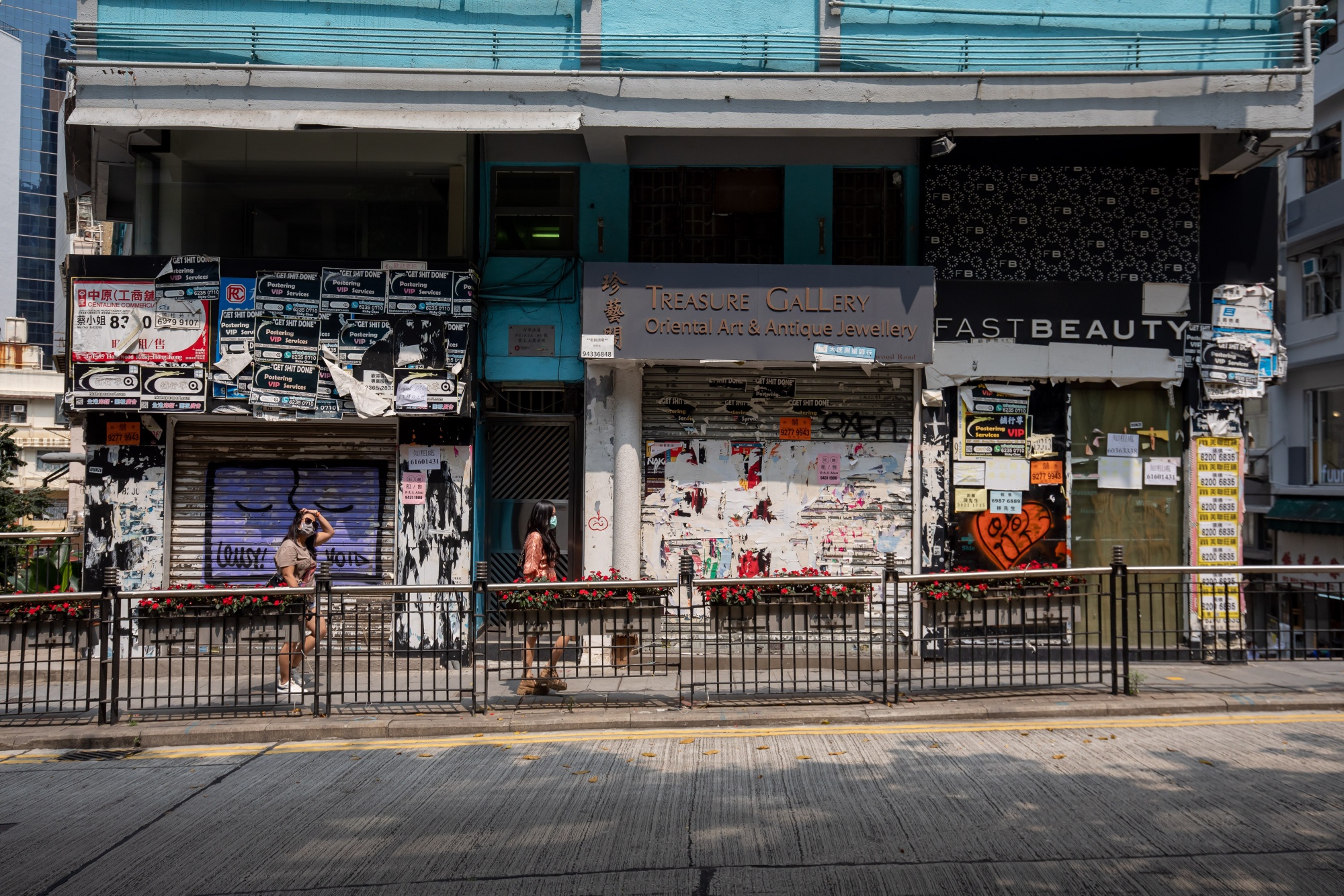 Pedestrians wearing protective masks walk past shuttered retail spaces&nbsp;in Hong Kong, on March 16.