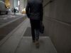 A pedestrian walks along a street near the New York Stock Exchange.