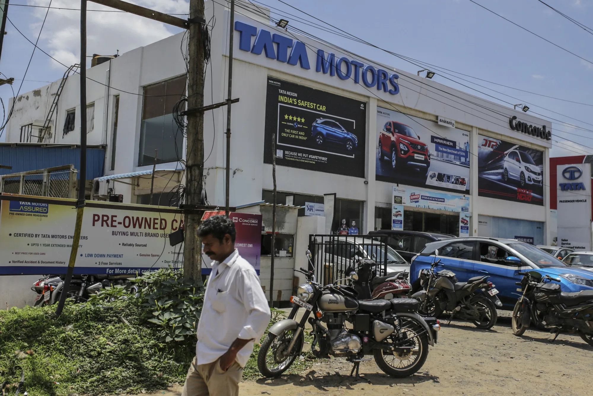 A pedestrian walks past a Tata Motors Ltd. showroom in the Ambattur district of Chennai, India.&nbsp;