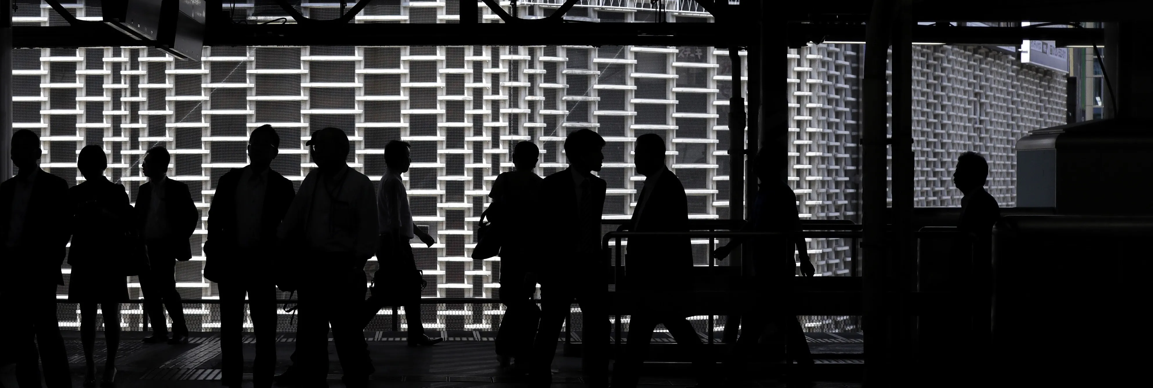 Passengers are silhouetted as they walk on the platform at a station in Tokyo, Japan, on Monday, June 5, 2017. Japan's revised first-quarter gross domestic product (GDP) figures will be released on June 8th.