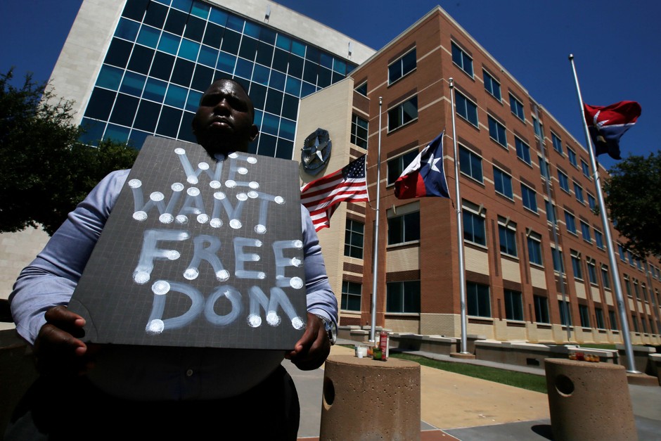 A man holds a sign at Dallas Police Headquarters following the shooting of 12 police officers in Dallas, Texas.