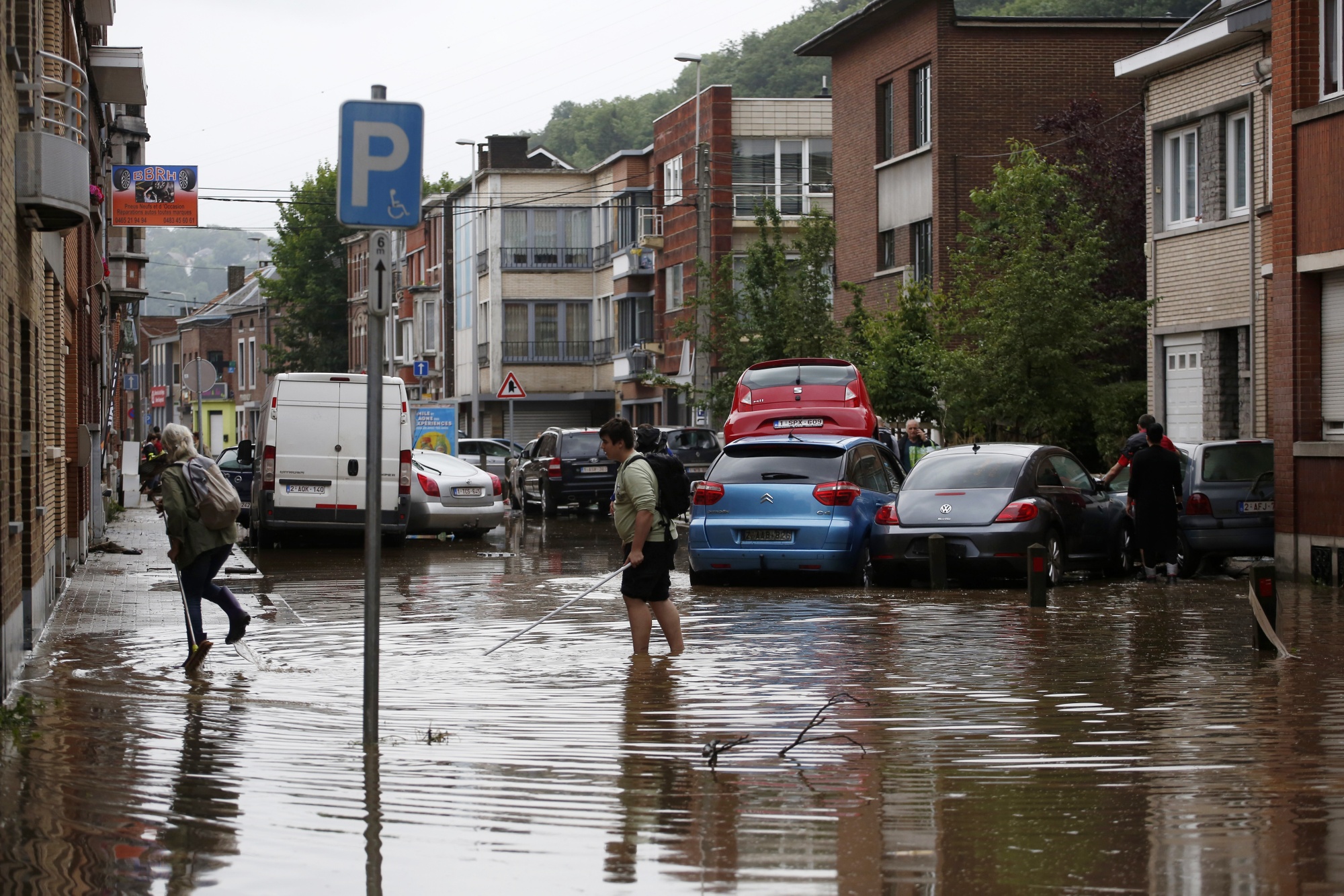 Residents wade through flood water on a flooded street in Angleur near Liege, Belgium in&nbsp;July&nbsp;2021.