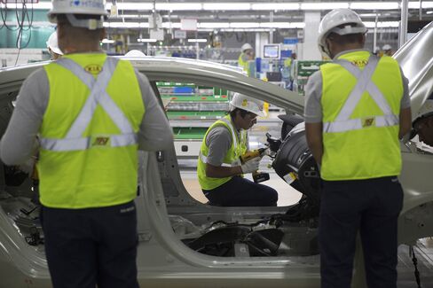 Workers check the chassis of a vehicle during a test at the Kia Motors assembly plant.