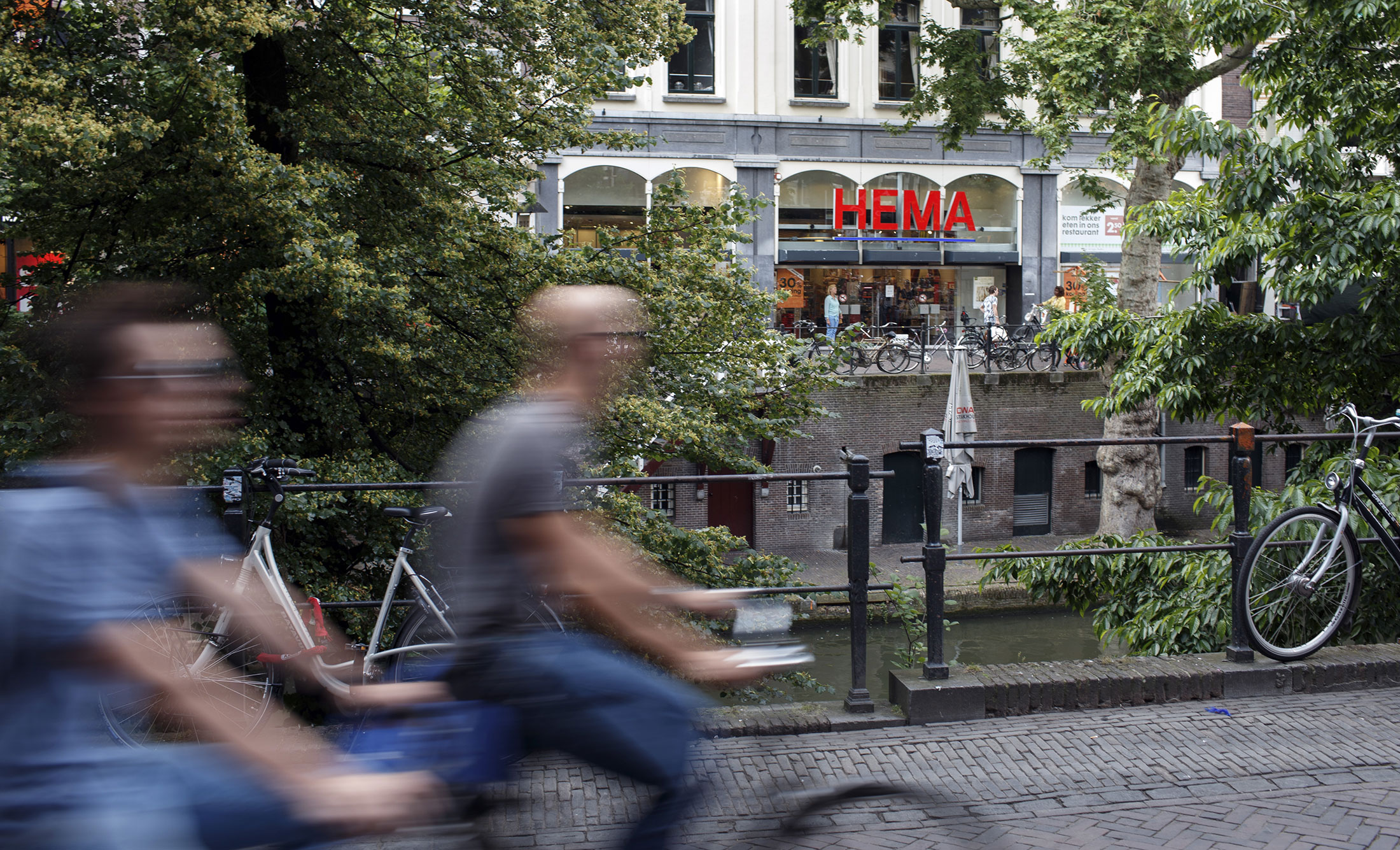 Cyclists ride bicycles near a Hema store in Utrecht.
