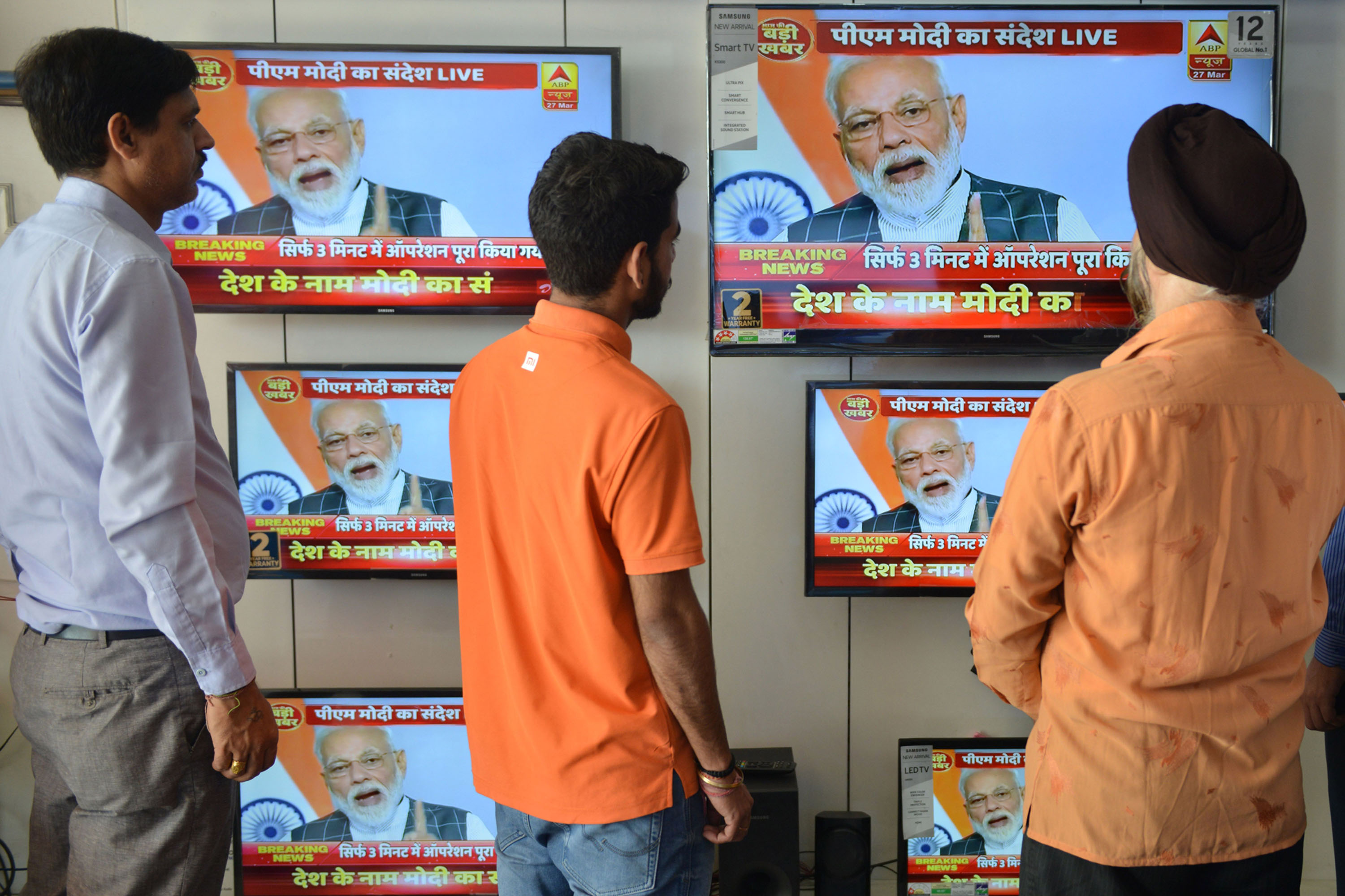 People watch a&nbsp;live broadcast of&nbsp;Narendra Modi addressing&nbsp;the nation, in Amritsar on March 27.&nbsp;
