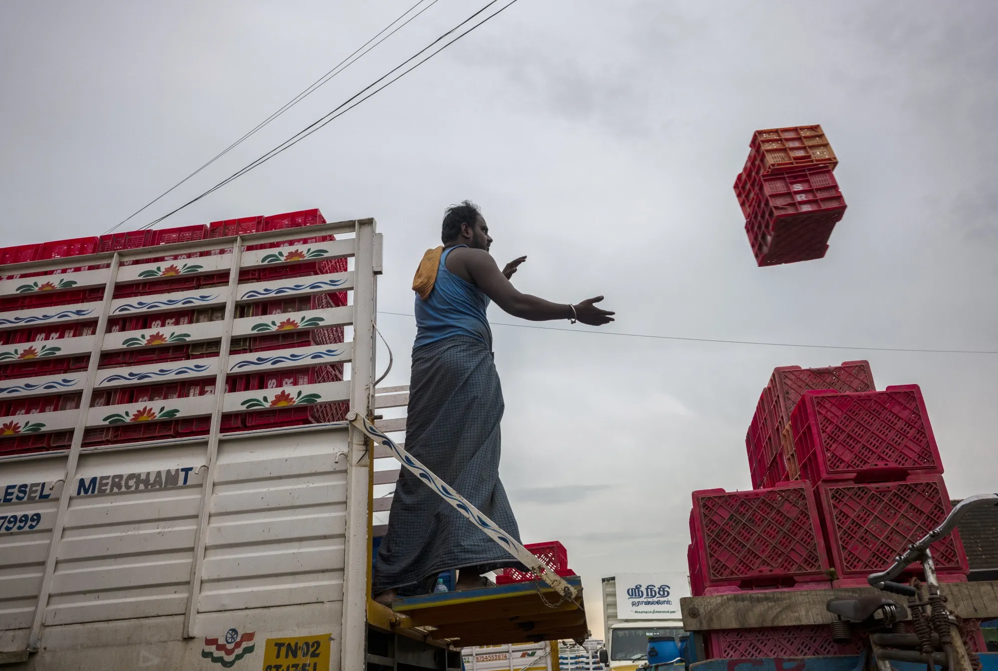 A worker prepares to catch empty crates at a wholesale vegetable market in Chennai, India, on Thursday, Sept. 23, 2021.&nbsp;