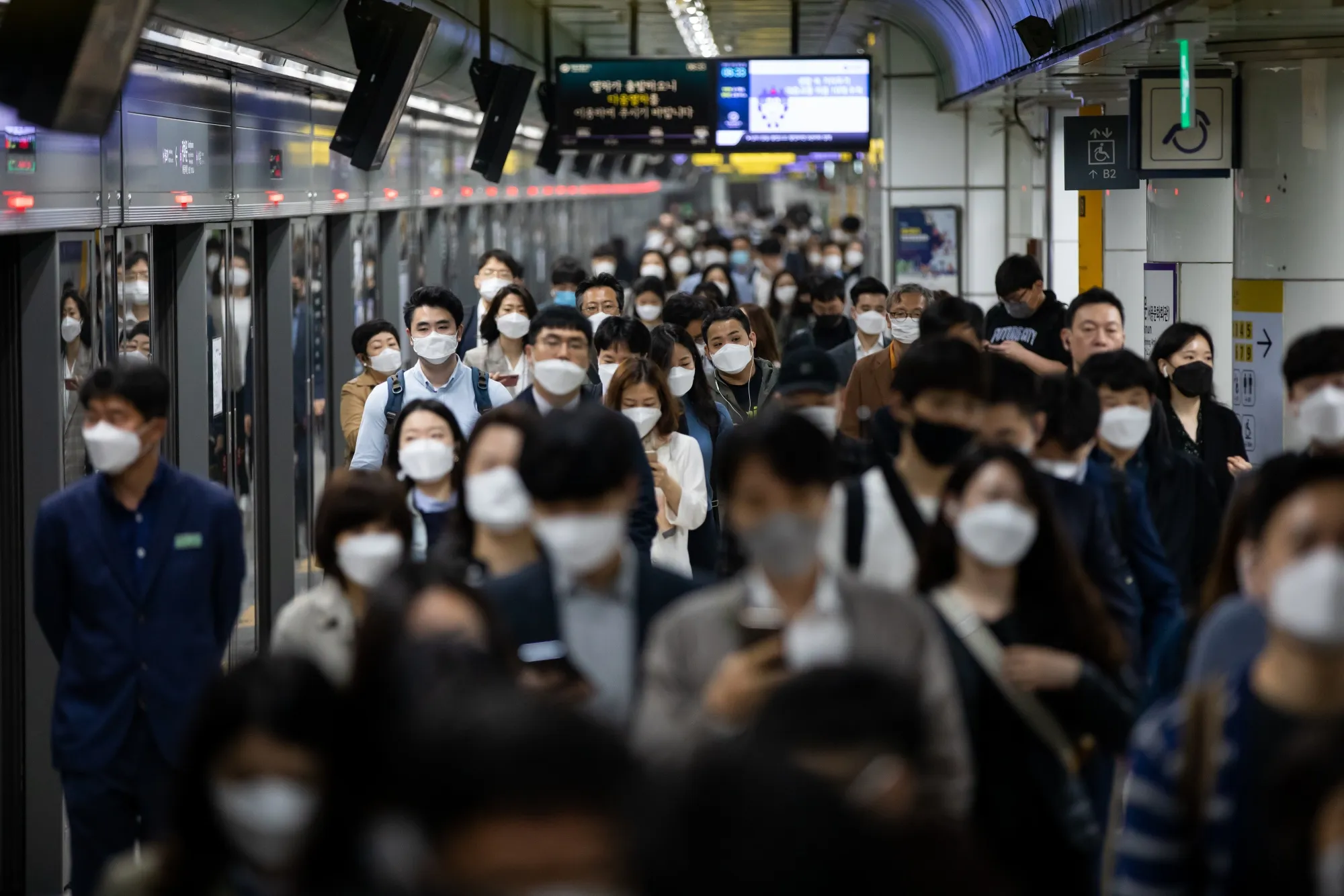 Passengers wearing protective masks walk through the subway station in Seoul on May 18.