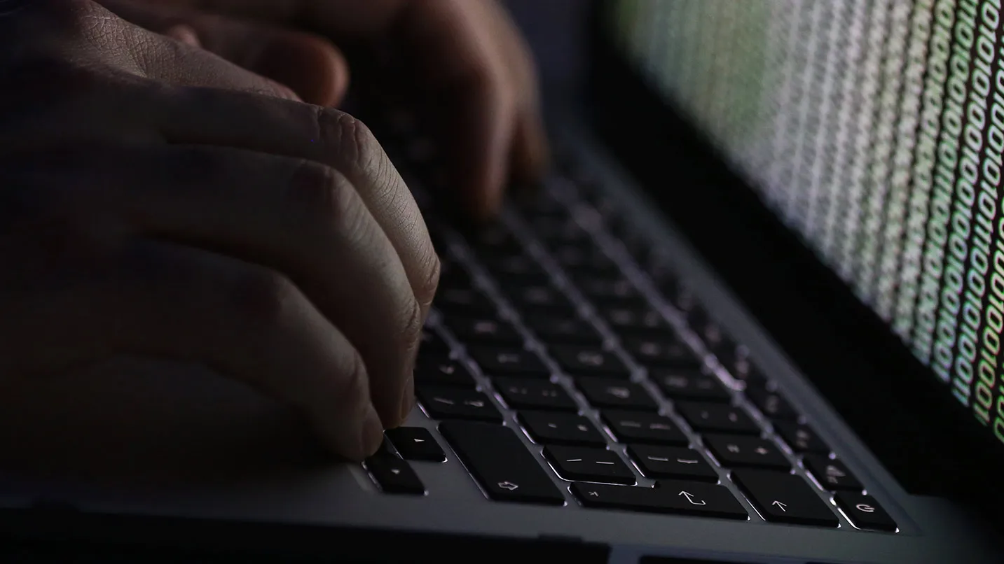 A stream of binary coding, text or computer processor instructions, is seen displayed on a laptop computer screen as a man works to enter data on the computer keyboard in this arranged photograph in London, U.K., on Wednesday, Dec. 23, 2015. The U.K.s biggest banks fear cyber attacks more than regulation, faltering economic growth and other potential risks, and are concerned that a hack could be so catastrophic that it could lead to a state rescue, according to a survey.
