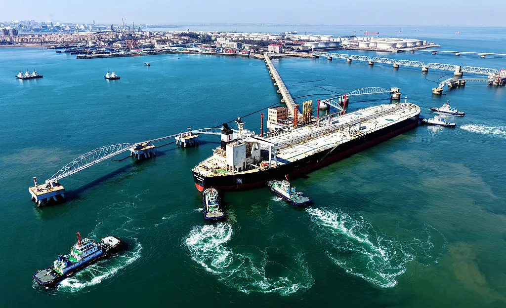 A crude oil tanker is guided to a berth at the oil terminal at the port in Qingdao, China.