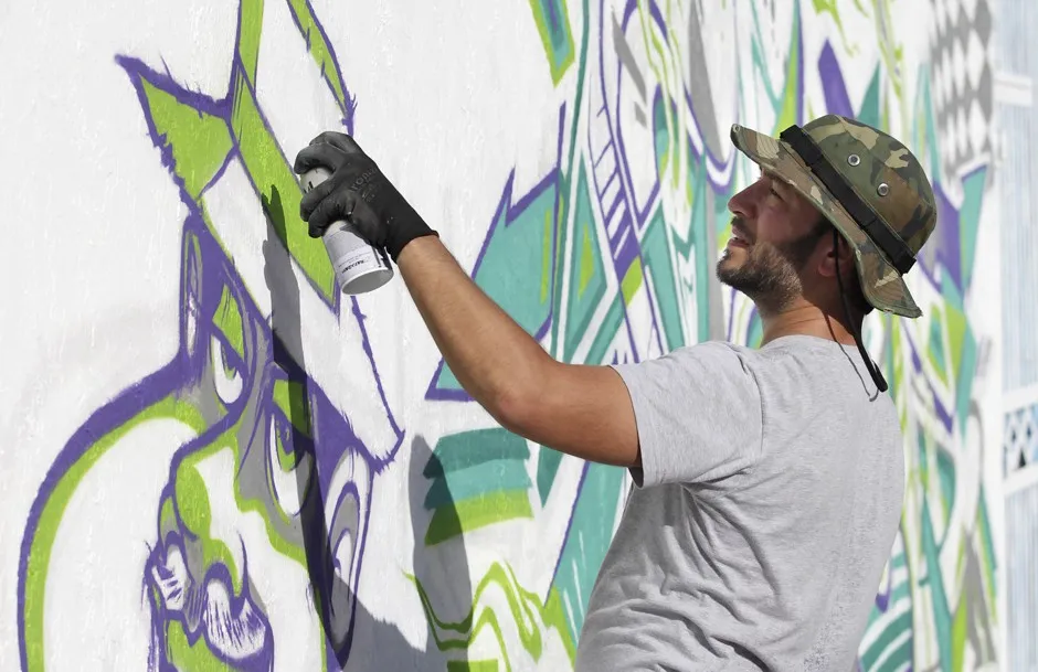 Graffitti artist Anthony Arias works on a mural during the Art Basel Miami Beach fair in 2014.