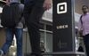Pedestrians walk past the Uber Technologies Inc. headquarters building in San Francisco, California.