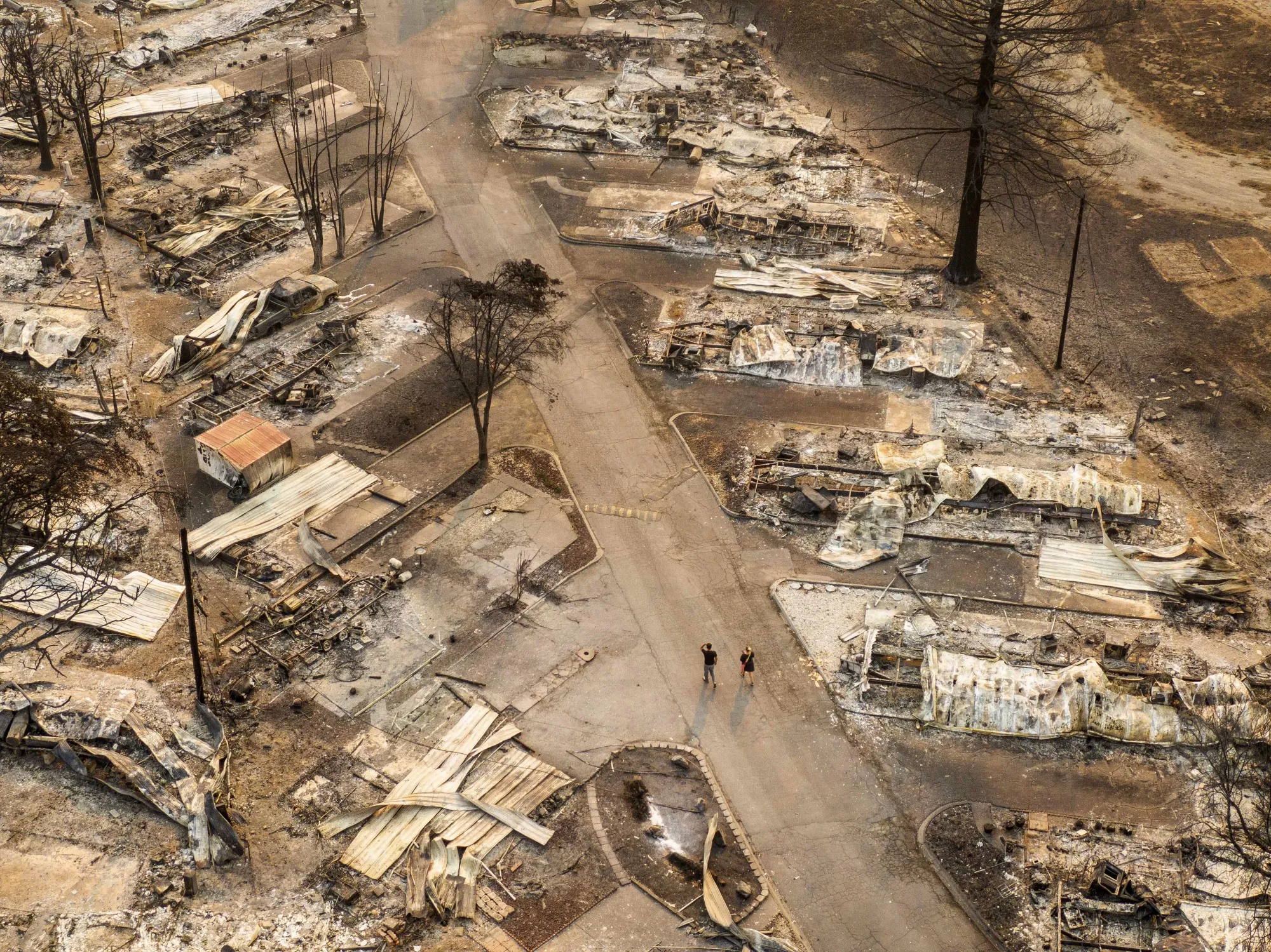 Residents walk through a mobile home park destroyed by fire&nbsp;in Phoenix, Oregon, in 2020.