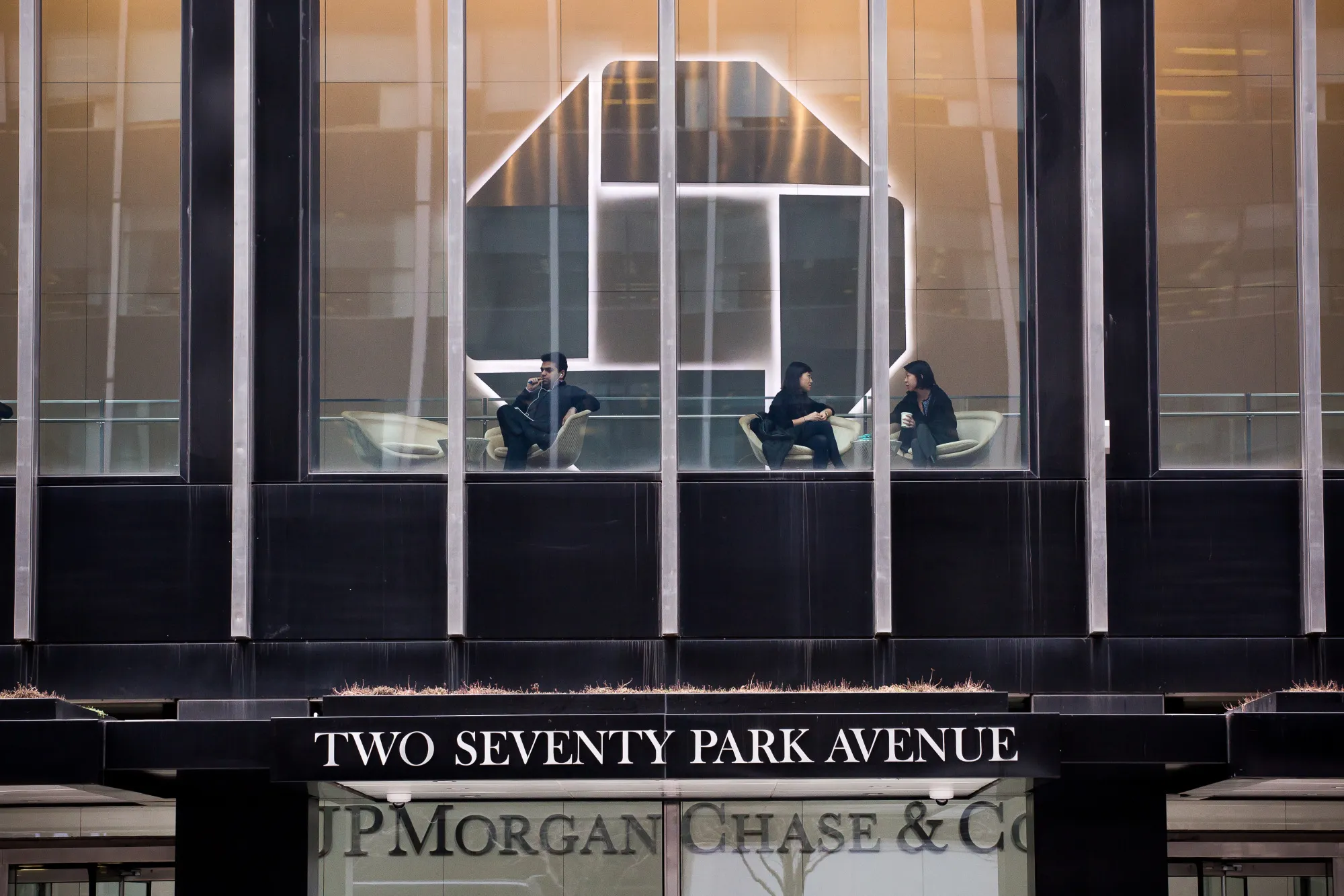 People sit inside the headquarters of JPMorgan Chase &amp; Co. in New York.
