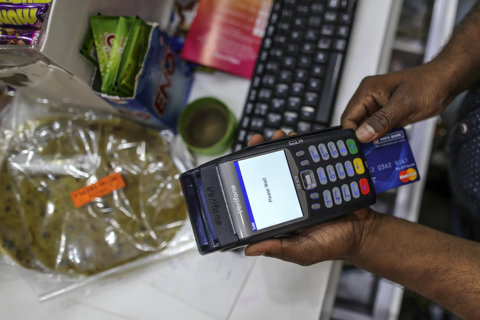 An employee uses a payment terminal at a supermarket.&nbsp;