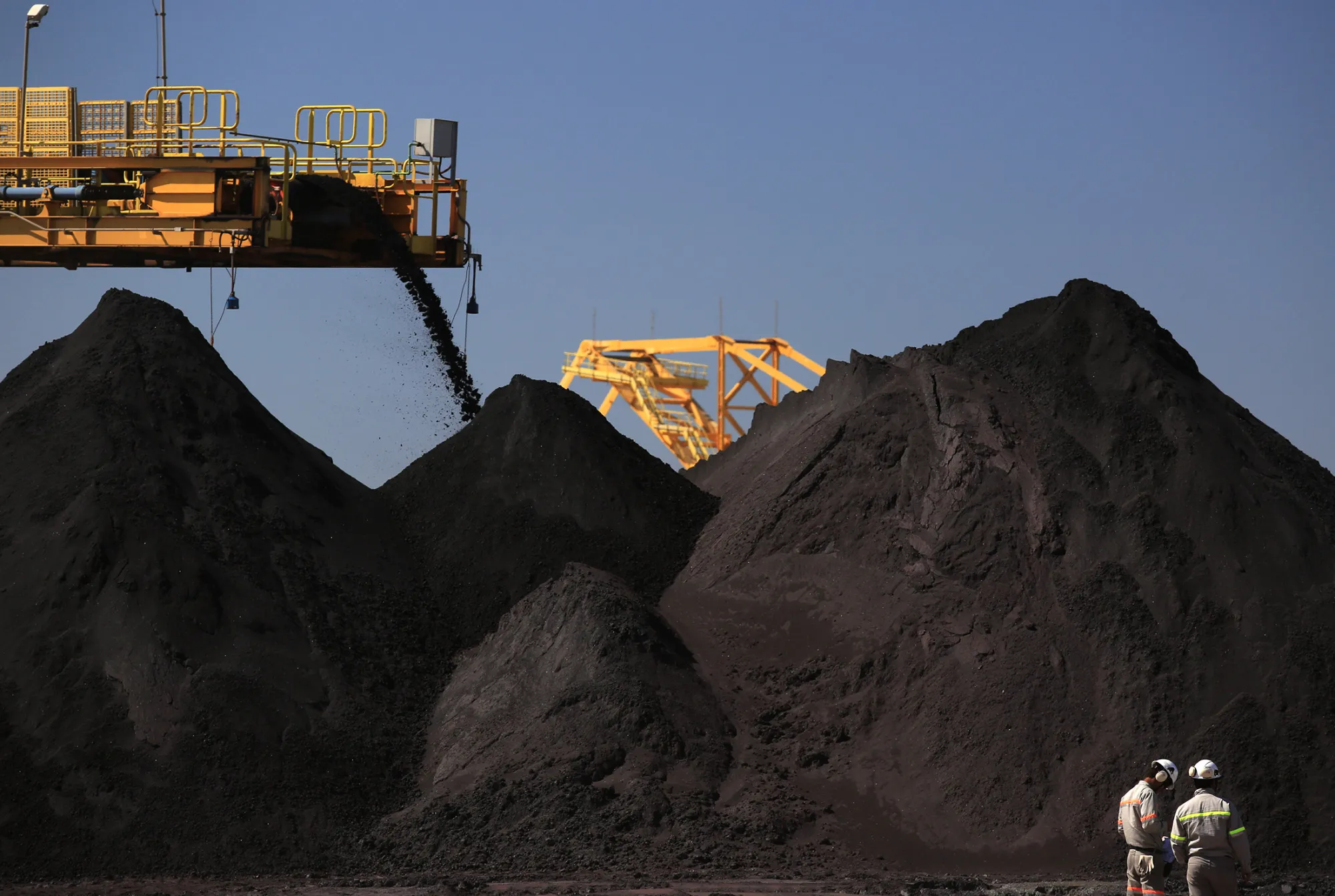 Iron ore is transported and dropped into stockpiles in the Ferroport yard at the Acu Port.
