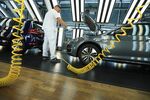 An employee inspects the electric connections under the hood of a Volkswagen e-Golf electric automobile&nbsp;at the Volkswagen AG factory in Dresden.