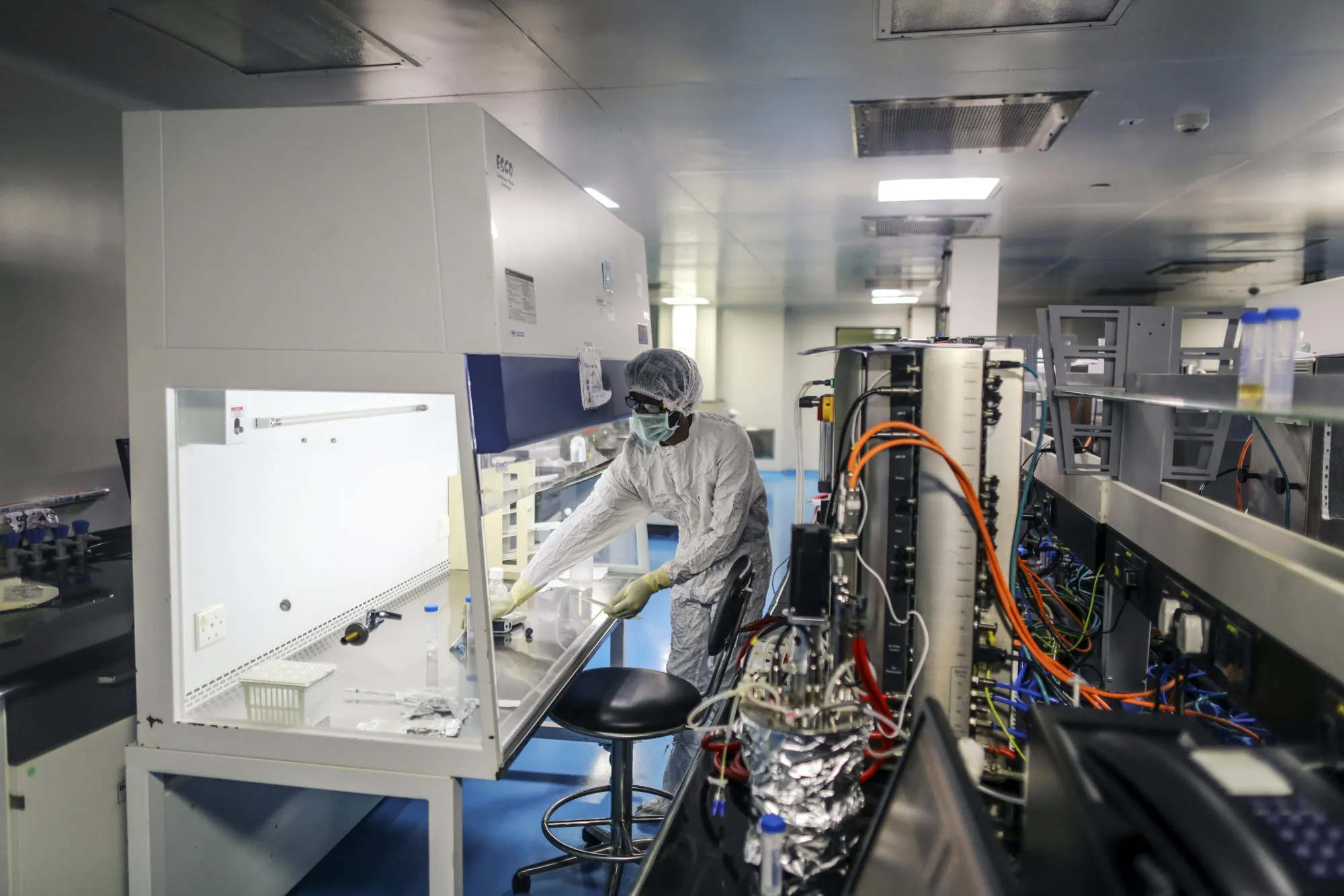 An employee in protective clothing works inside the research and development center at the Biocon Ltd. campus in Bengaluru.