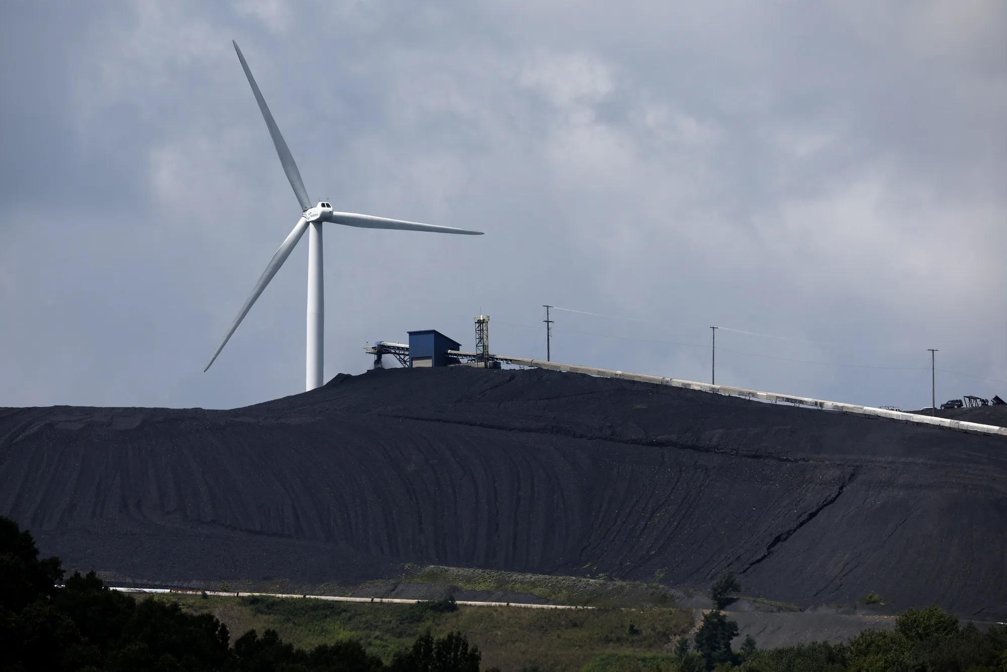 A wind turbine stands behind a coal processing plant&nbsp;in Oakland, Maryland.&nbsp;