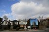 Houses marked for demolition stand next to a billboard advertising a future condominium to stand in their place in Toronto.