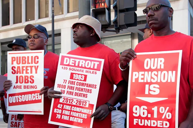 Members of the Detroit Fire Department (DFD) hold signs while protesting in front of the Theodore Levin U.S. Courthouse in Detroit on July 24