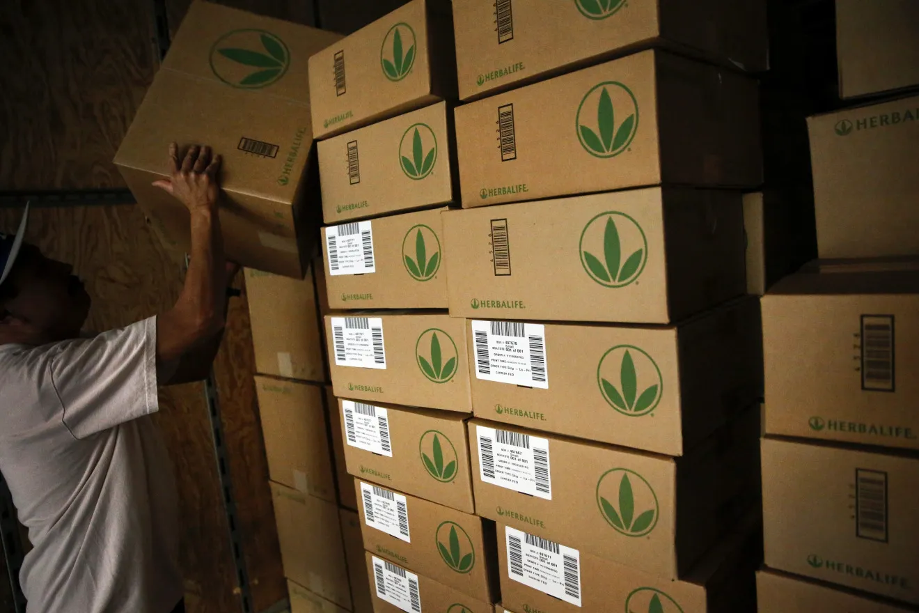 An employee stacks boxes of products for orders at the Herbalife Ltd. Los Angeles distribution center in Carson, California, U.S., on Tuesday, March 4, 2014.