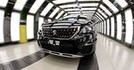 A Peugeot 3008 compact SUV drives through a light tunnel at the Peugeot plant in Sochaux, France.