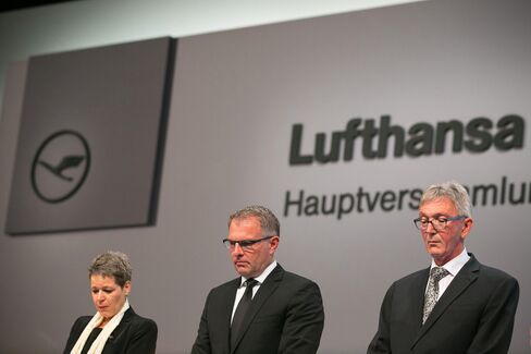 Simone Menne, chief financial officer of Deutsche Lufthansa AG, left, Carsten Spohr, chief executive officer of Deutsche Lufthansa AG, center, and Wolfgang Mayrhuber, chairman of Deutsche Lufthansa AG, observe a minute's silence for the victims of last month's Germanwings aircrash during the airline's AGM in Hamburg on April 29, 2015.