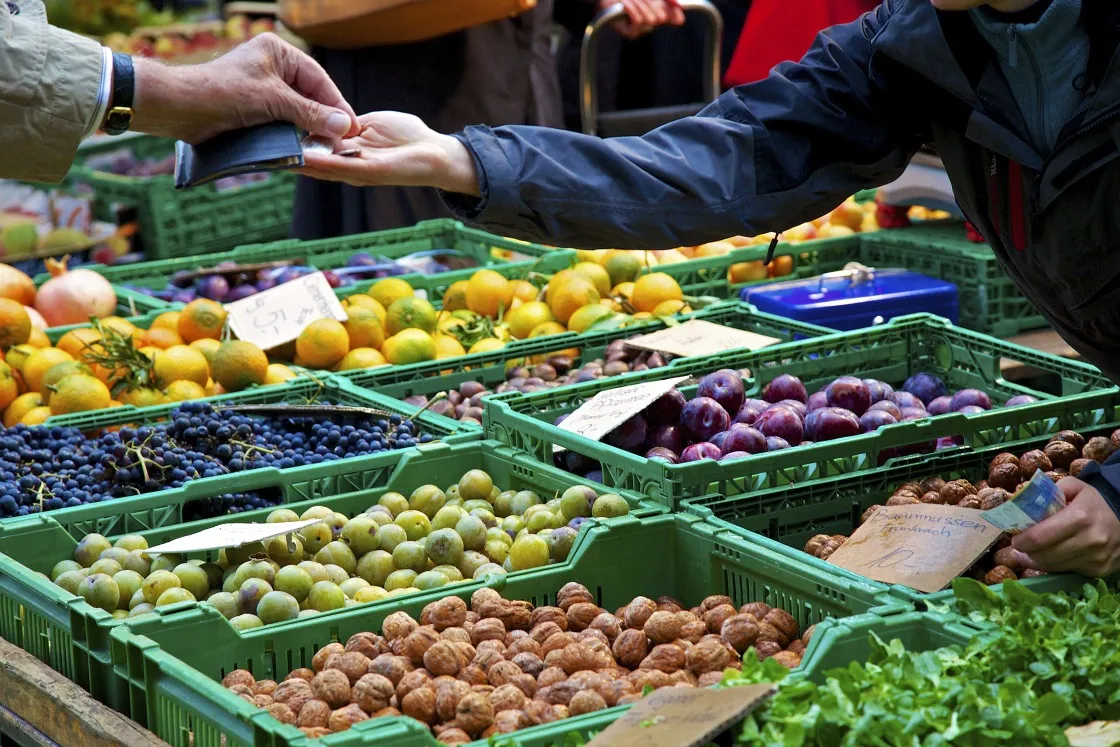 A customer pays a trader at a market in Zurich.