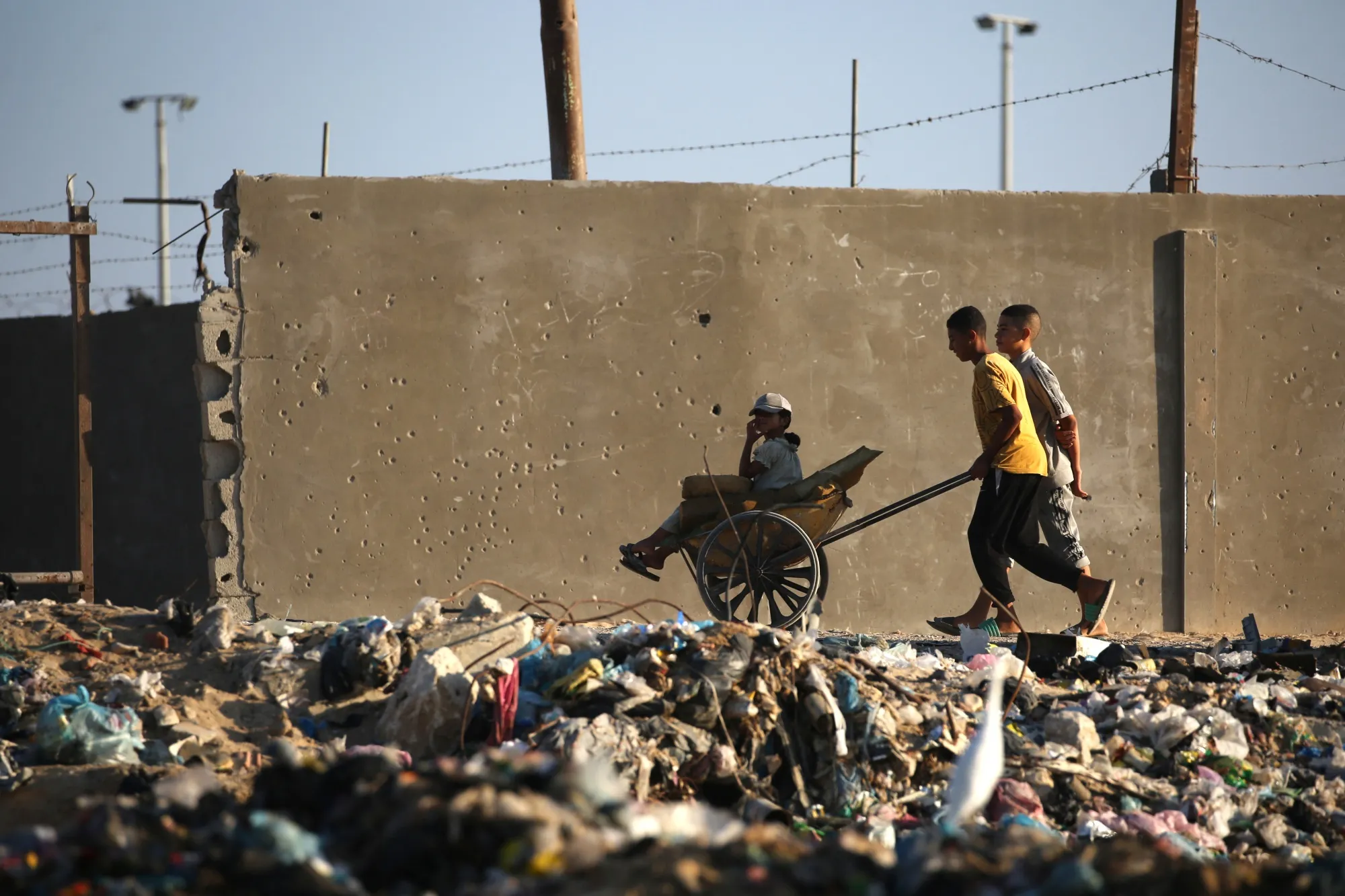 Palestinians walk past a pile of garbage in Deir al-Balah, Gaza, on Oct. 13.