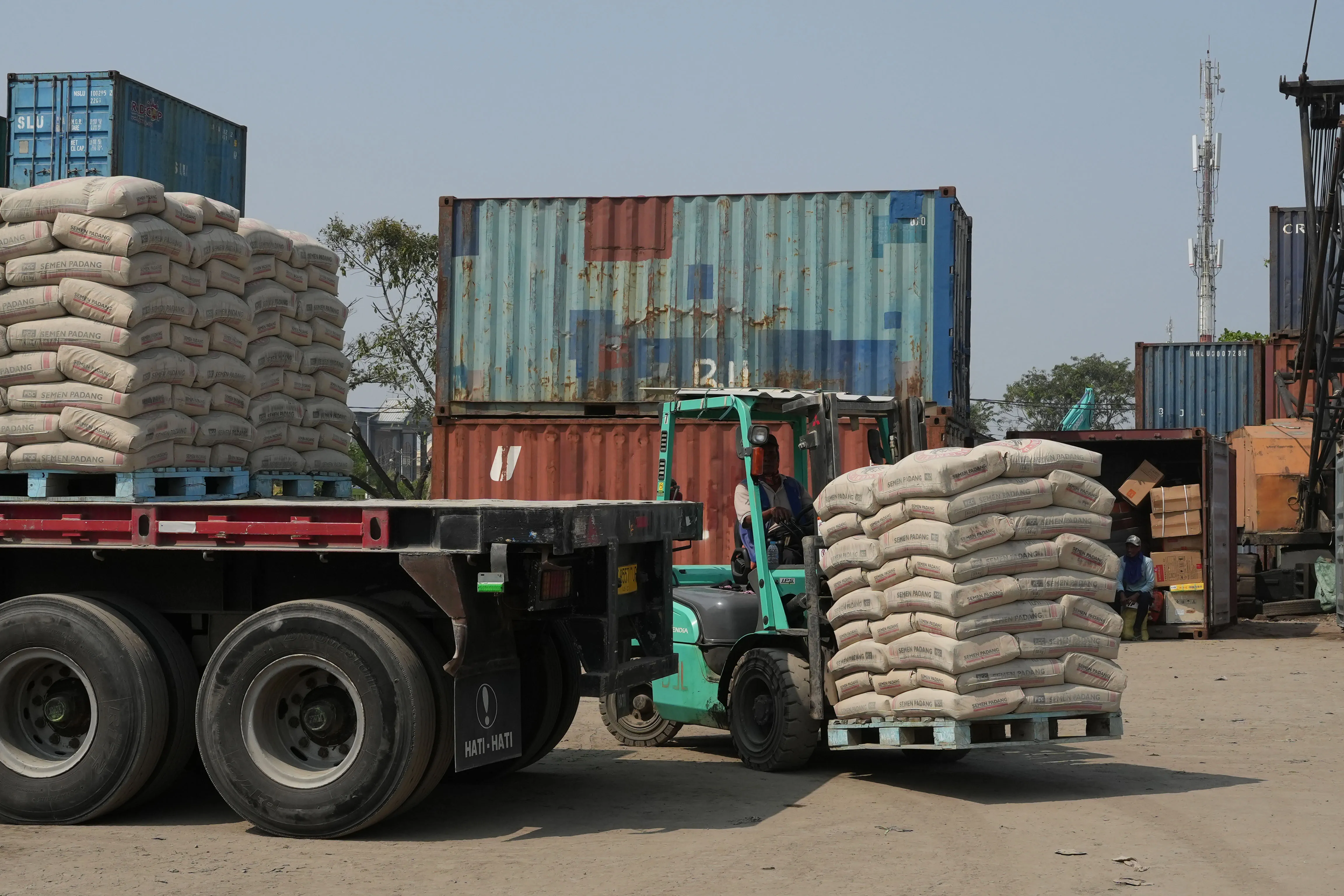 A worker operates a forklift to transport sacks of cement&nbsp;at the Sunda Kelapa Port in Jakarta.