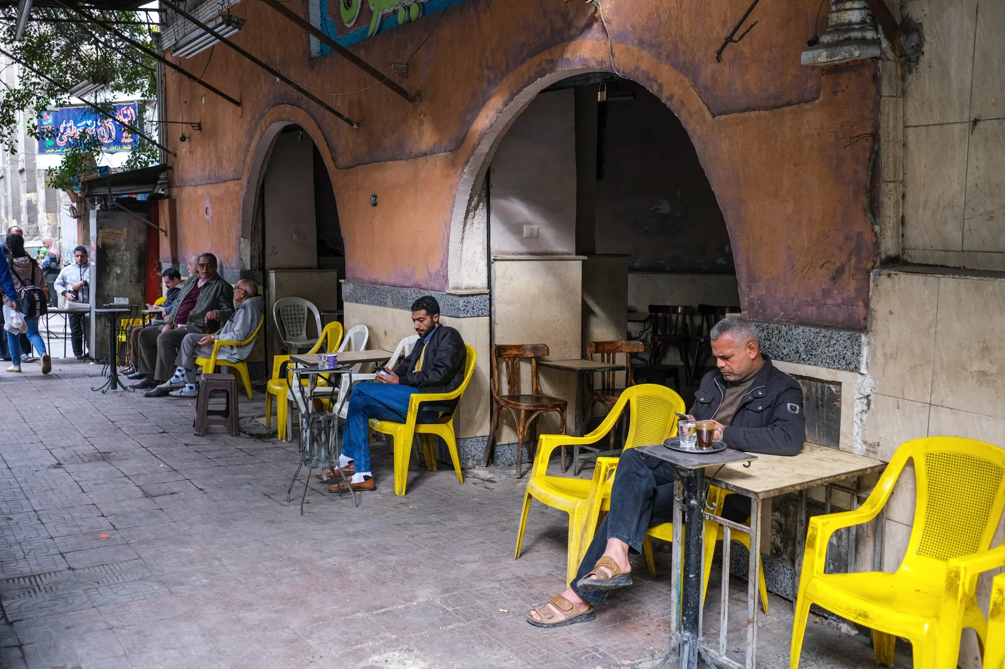 Diners use their phones outside a Cairo cafe.