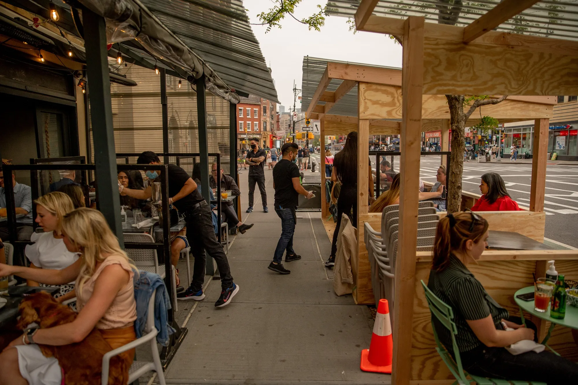 Customers sit in the outdoor dining area of a restaurant in New York.