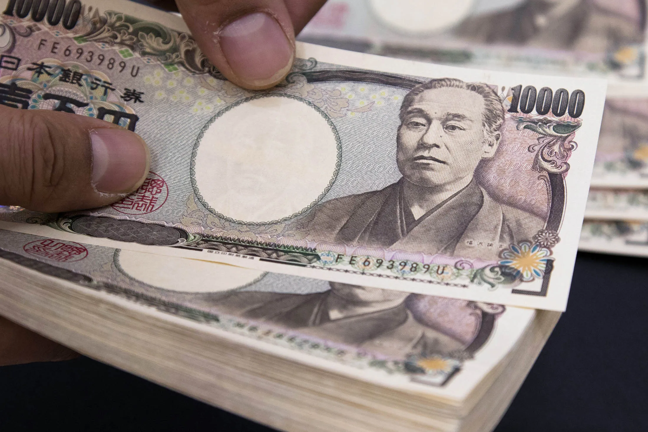 An employee counts Japanese 10,000 yen banknotes in an arranged photograph at the Korea Exchange Bank headquarters in Seoul, South Korea, on Monday, March 16, 2015. The yen fell this month to the weakest against the greenback since 2007 as the Bank of Japan sustains its record stimulus to support the economy while the U.S. recovery raises prospects of higher interest rates.
