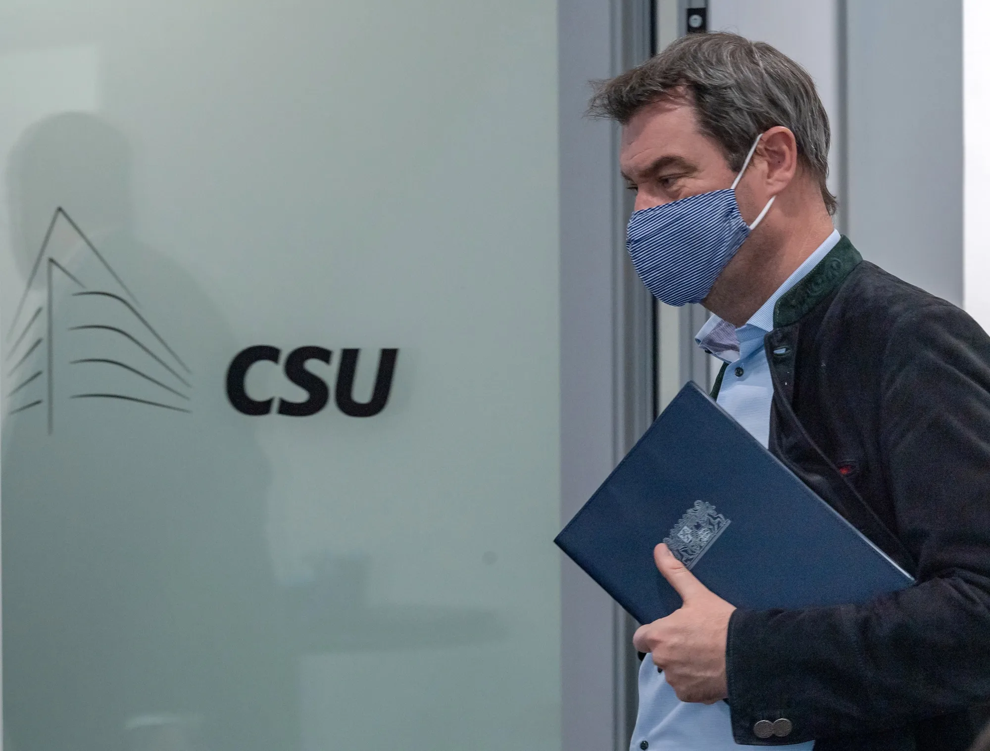 Markus Soeder leaves the room following a press conference, in Munich, on April 27.