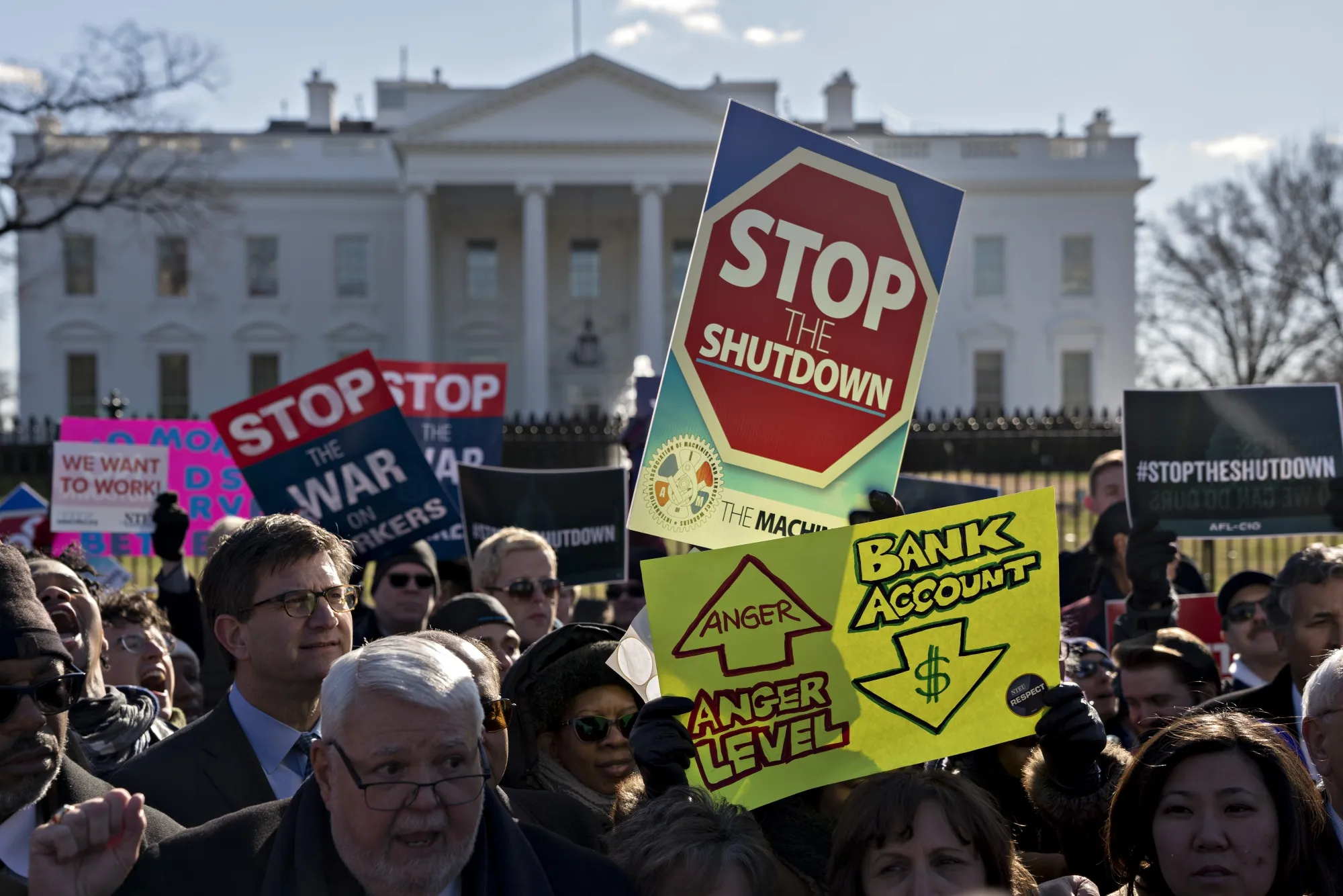 A demonstrator holds a "Stop The Shutdown" sign during a rally with union members and federal employees to end the partial government shutdown outside the White House in Washington, D.C., U.S., on Thursday, Jan. 10, 2019.&nbsp;