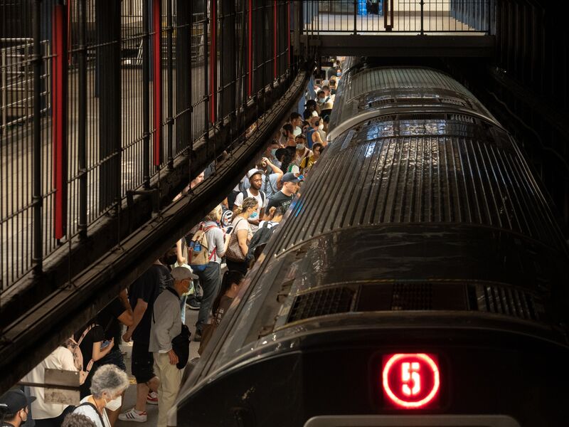 Commuters wait on the platform of a subway station in New York.