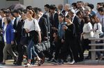Morning commuters walk across a road in the Shinjuku District in Tokyo, Japan, on Tuesday, May 15, 2018.