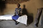 Winnie Keben sits on her bed at Meisori village in Baringo County, Kenya, Wednesday, July 20, 2022. Keben lost her leg to a crocodile attack, and that accident plus the loss of her home to rising water drove her and her family from their village. (AP Photo/Brian Inganga)
