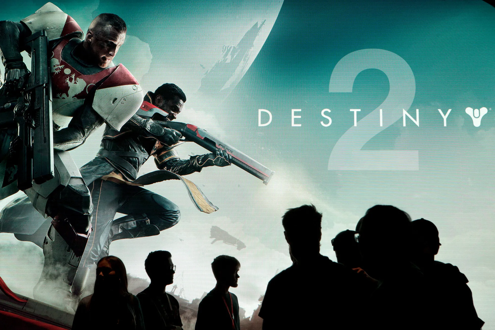 Attendees walk past signage for the Activision Blizzard Inc. "Destiny 2" video game, developed by Bungie Inc., during the E3 Electronic Entertainment Expo in Los Angeles, California, U.S., on Wednesday, June 14, 2017.&nbsp;