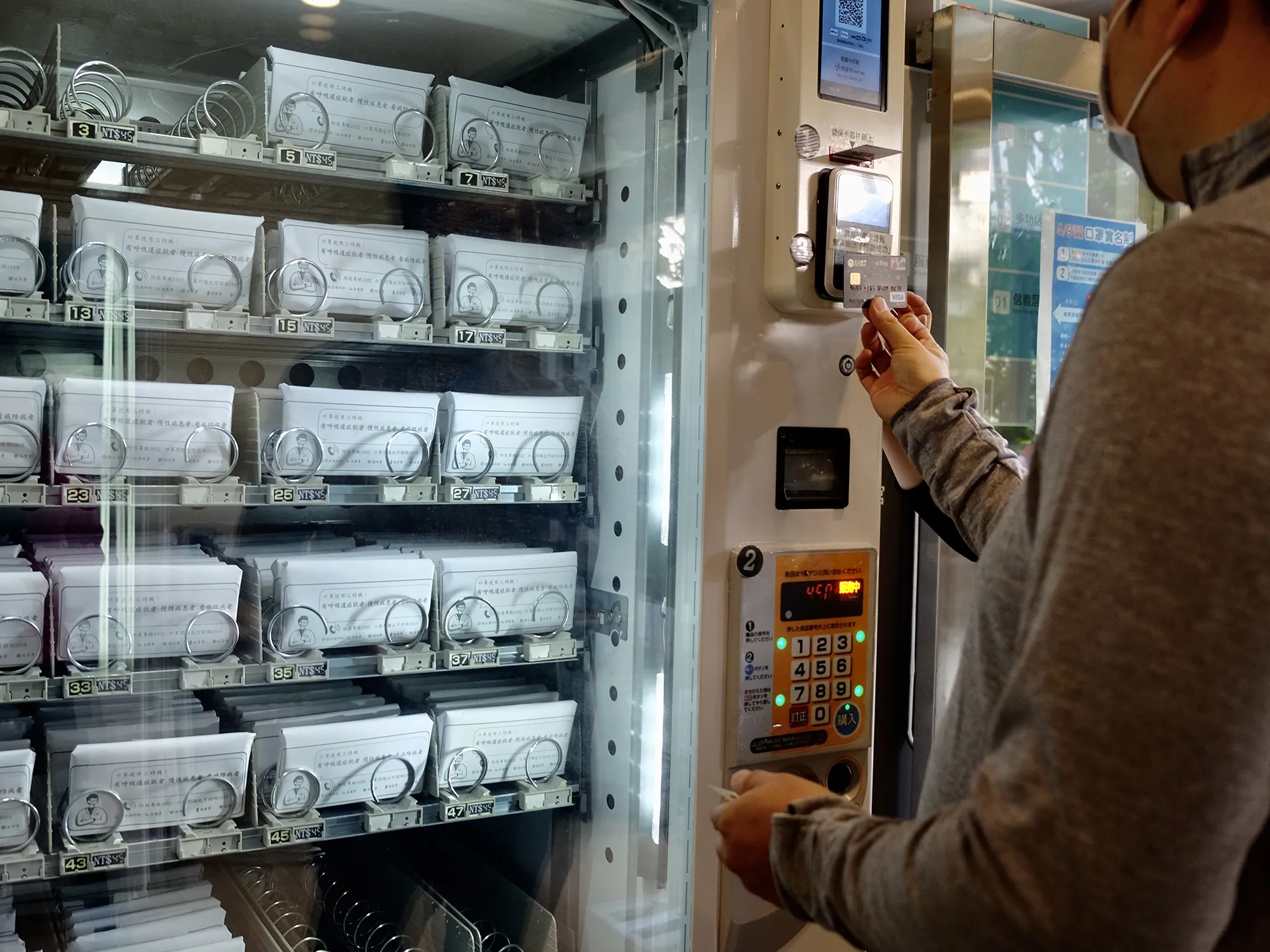 A resident buys face masks from a vending machine&nbsp;in Taipei on April 14.