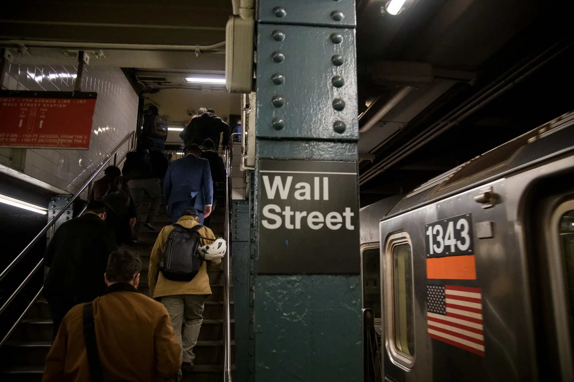 Commuters exit a Wall Street subway station.