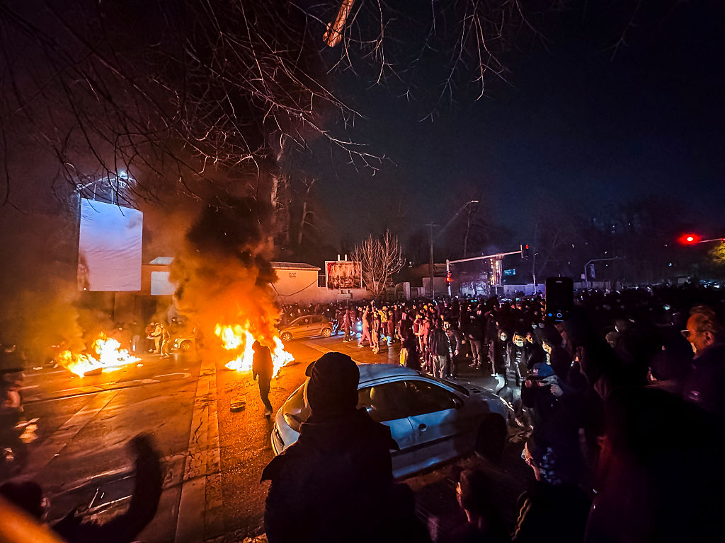 Iranians gather while blocking a street during a protest in Tehran, Iran on January 9, 2026. The nationwide protests started in Tehran's Grand Bazaar against the failing economic policies in late December, which spread to universities and other cities, and included economic slogans, to political and anti-government ones. (Photo by MAHSA / Middle East Images / AFP via Getty Images)