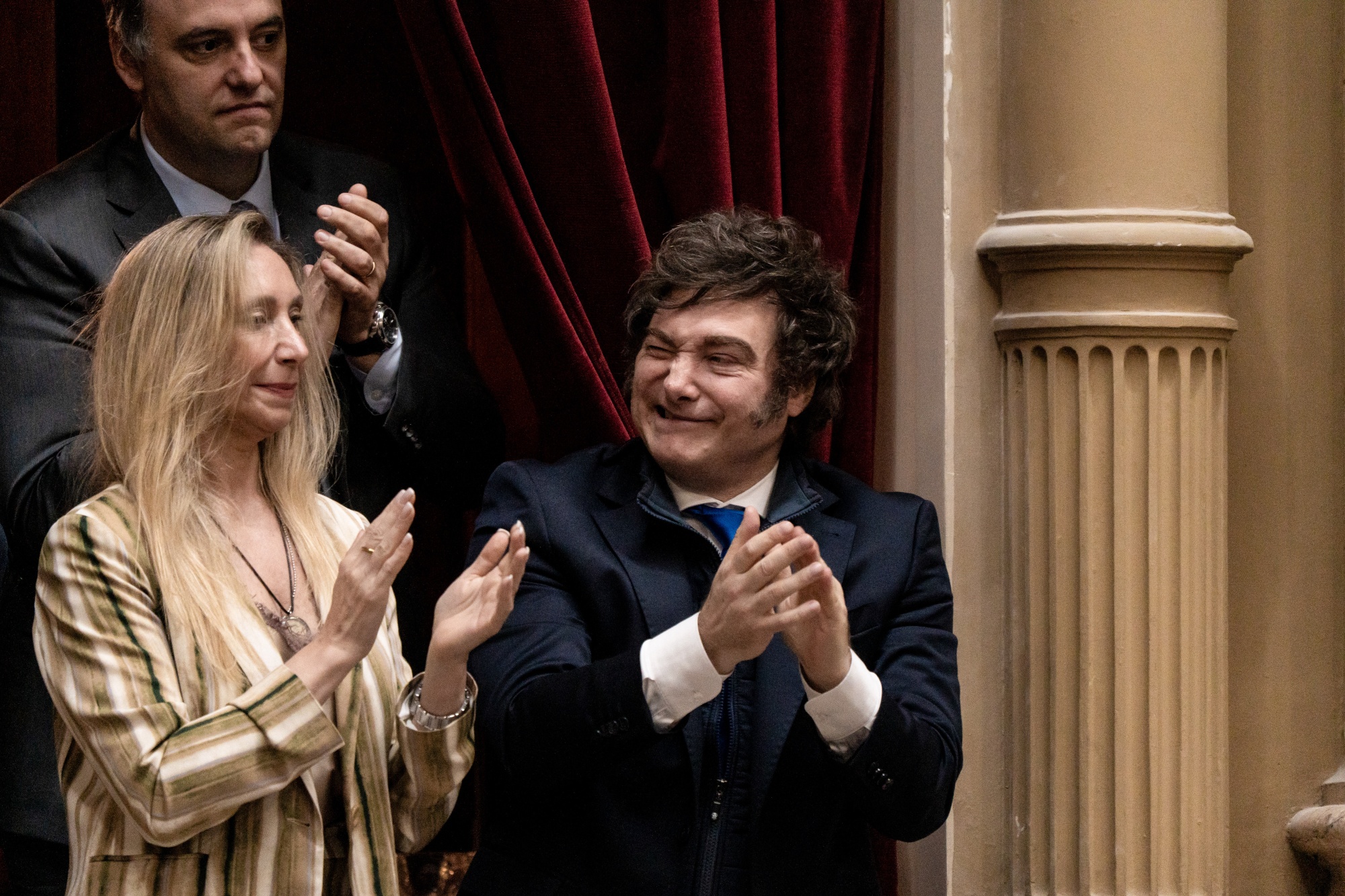 Javier Milei, flanked by his sister Karina and cabinet chief Manuel Adorni, applauds during a swearing in ceremony at the National Congress in 2025.