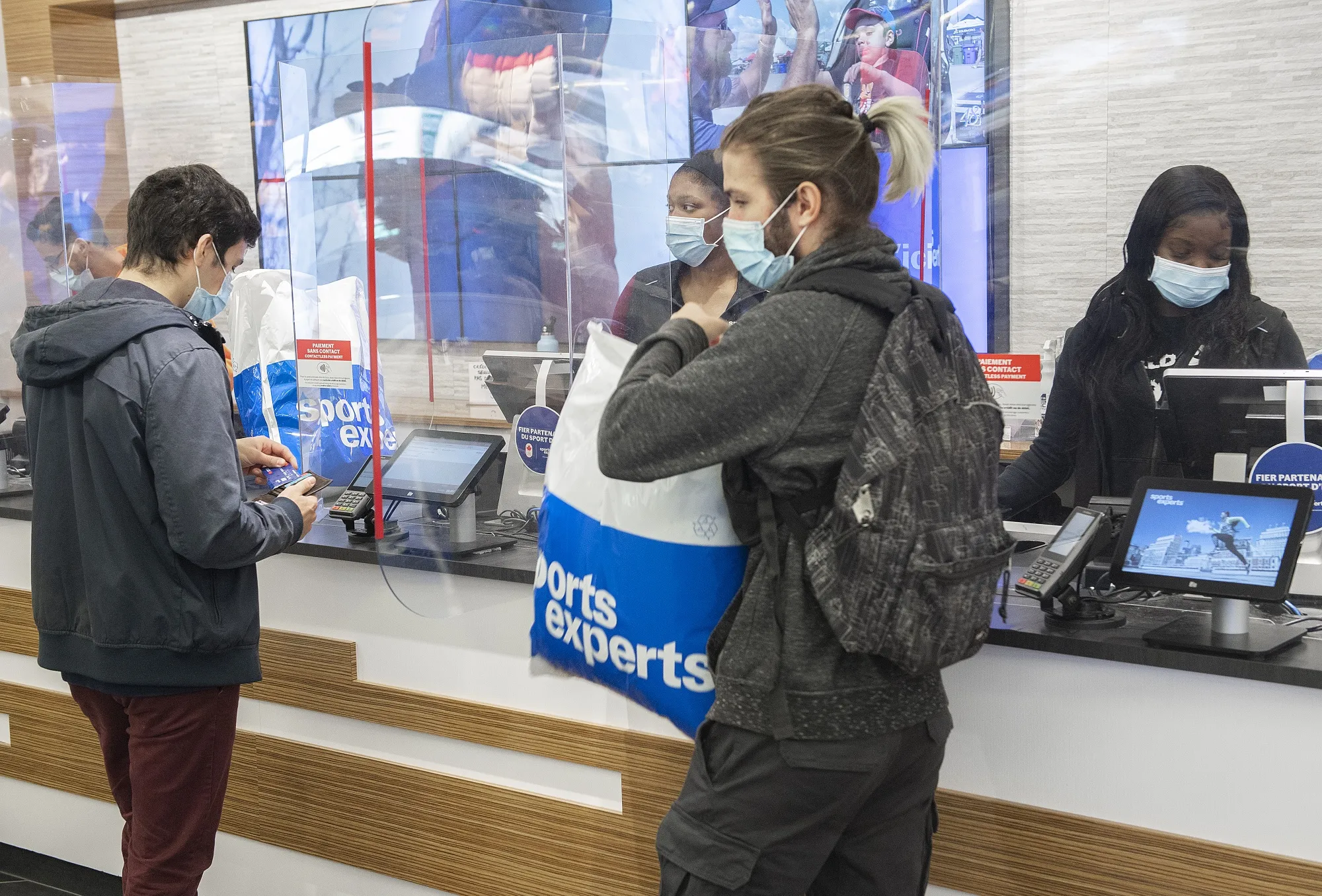 Shoppers check out at a Montreal sporting goods store on Oct. 6. An early reading shows the Canadian economy grew 0.8% on the month.
