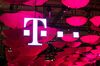 The T-Mobile logo for Deutsche Telekom AG's T-Systems unit, is seen suspended from the ceiling along with a collection of coloured umbrellas during the CeBit tech show in Hanover, Germany.