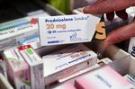 A pharmacist shows a box of Prednisolone by Sandoz, a drug containing cortisone on May 23, 2019 in Brest, western France. 