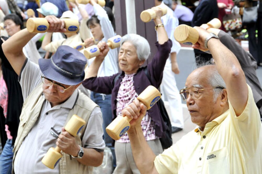 Elderly people work out with wooden dumbbells in Tokyo