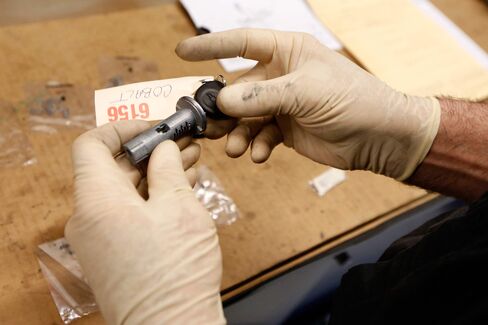 A shop foreman installs tumblers for the key cylinder during recall work on a 2005 GM Chevrolet Cobalt.